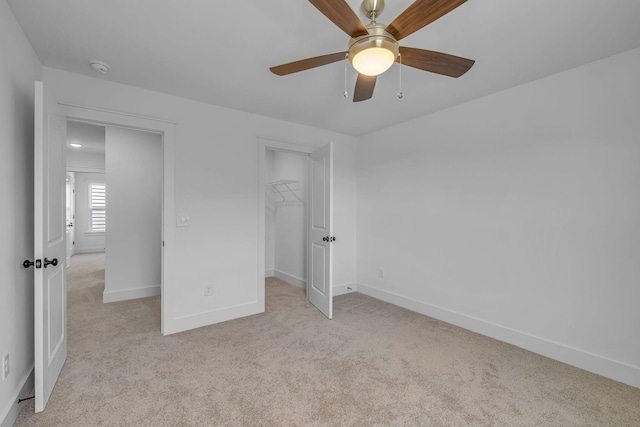 698 Conifer Dr, Spring Hill, TN 37174 - unfurnished bedroom featuring light colored carpet, baseboards, a closet, ceiling fan, and a walk in closet