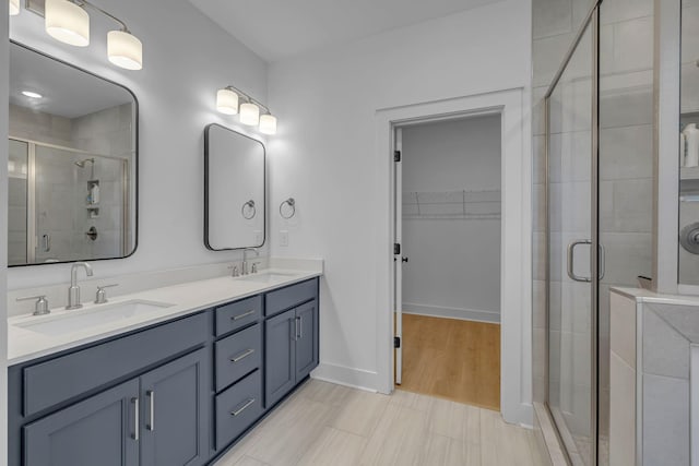 698 Conifer Dr, Spring Hill, TN 37174 - bathroom with a shower stall, a spacious closet, double vanity, and baseboards