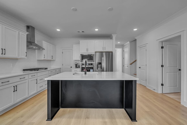 698 Conifer Dr, Spring Hill, TN 37174 - kitchen featuring appliances with stainless steel finishes, wall chimney exhaust hood, a sink, light countertops, and a center island with sink
