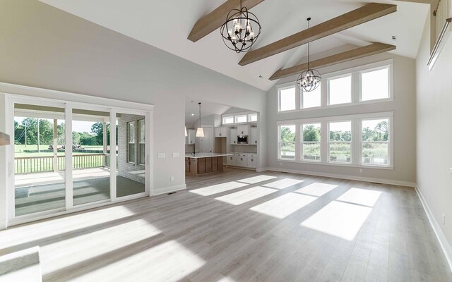 7295 NW Hwy, Fairview, TN 37062 - unfurnished living room with a chandelier, beamed ceiling, high vaulted ceiling, light wood-type flooring, and baseboards