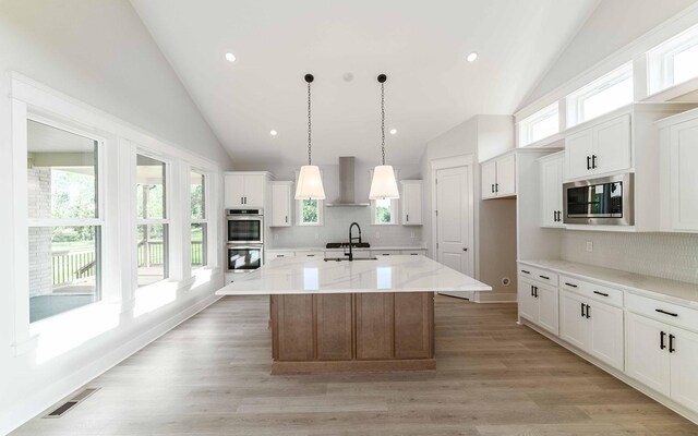 7295 NW Hwy, Fairview, TN 37062 - kitchen with stainless steel appliances, wall chimney exhaust hood, white cabinetry, tasteful backsplash, and high vaulted ceiling
