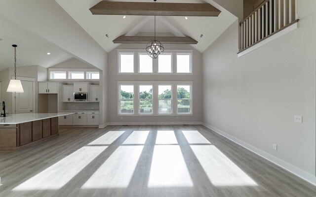 7295 NW Hwy, Fairview, TN 37062 - unfurnished living room featuring high vaulted ceiling, beam ceiling, healthy amount of natural light, light wood-type flooring, and baseboards