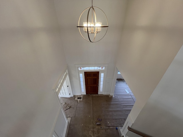 entrance foyer featuring a towering ceiling and a notable chandelier