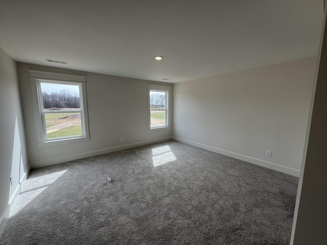 carpeted empty room featuring baseboards, visible vents, and recessed lighting