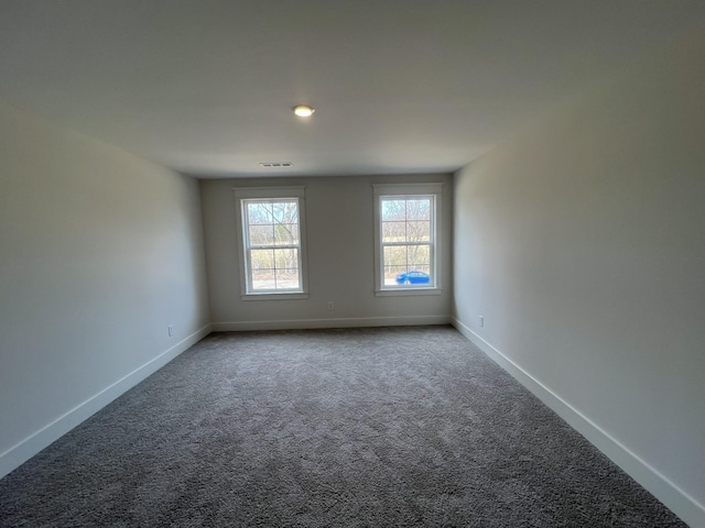 carpeted empty room with visible vents and baseboards