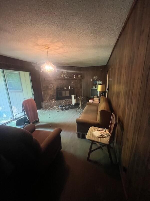 living room with wooden walls and a textured ceiling