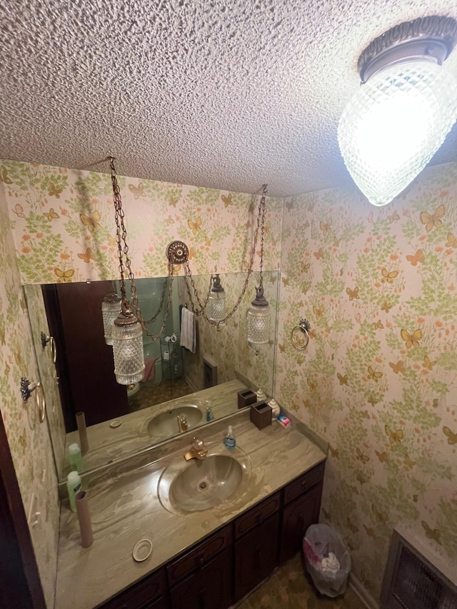 bathroom featuring wallpapered walls and vanity