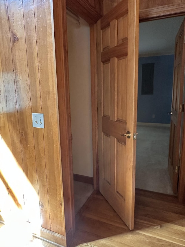 interior space featuring wood finished floors, wood walls, and baseboards