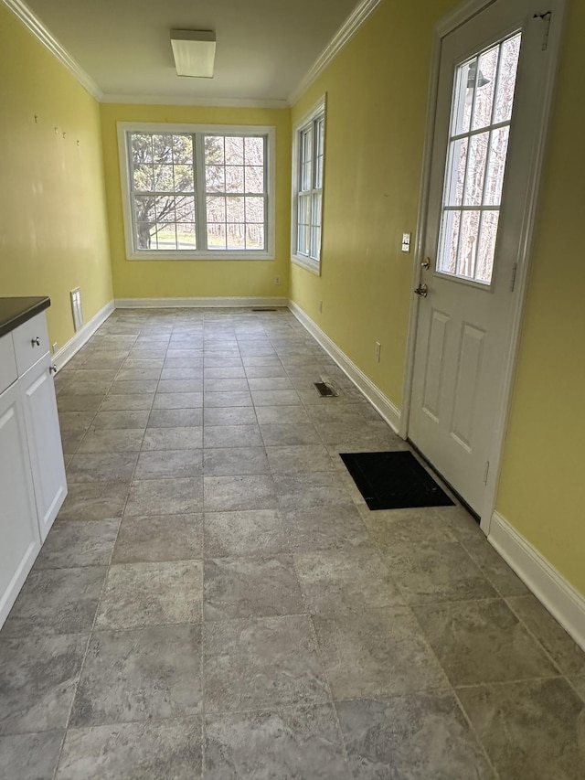 doorway to outside with baseboards, a wealth of natural light, and ornamental molding
