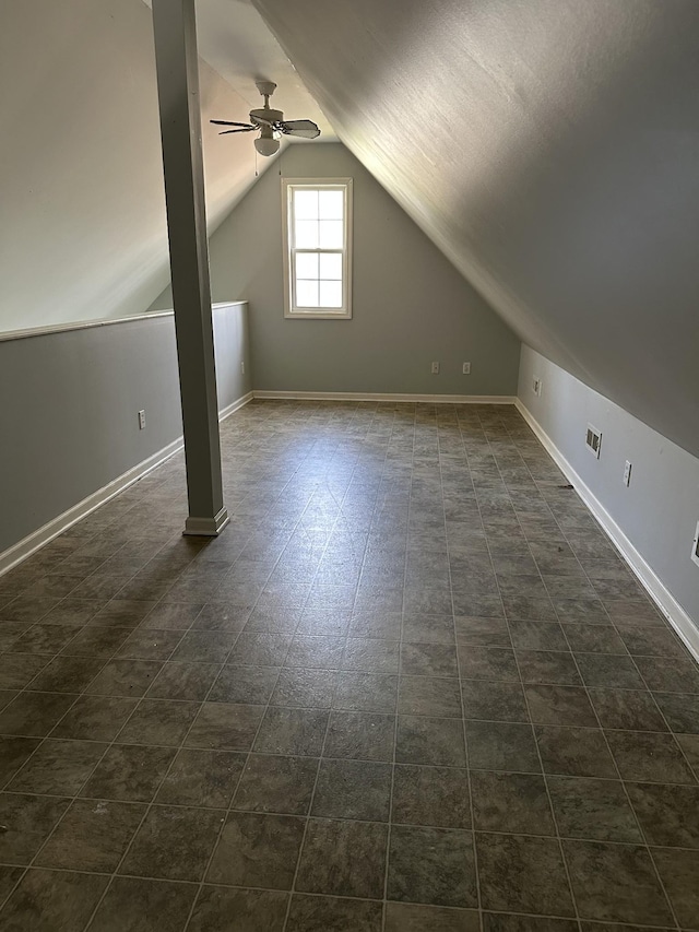 additional living space with lofted ceiling, baseboards, a ceiling fan, and visible vents