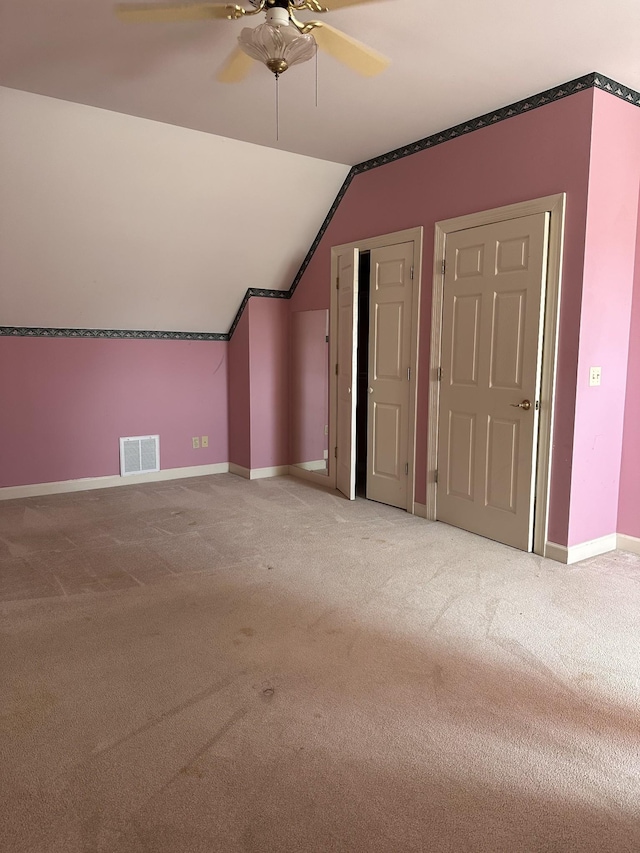 additional living space with vaulted ceiling, carpet, visible vents, and baseboards
