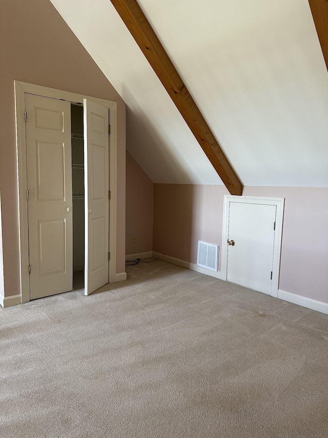 additional living space with lofted ceiling with beams, light carpet, visible vents, and baseboards