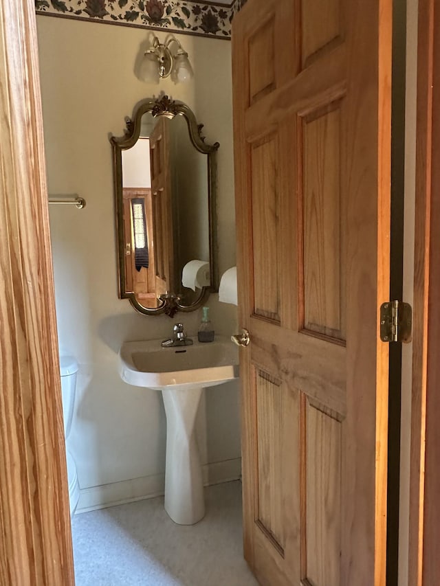 bathroom featuring toilet and baseboards