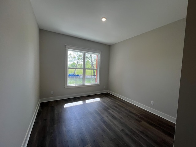 unfurnished room featuring baseboards, dark wood-type flooring, and recessed lighting