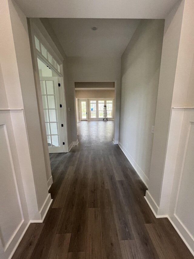 corridor with baseboards and dark wood finished floors