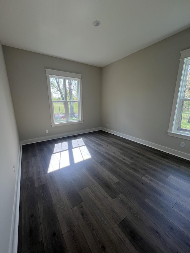 empty room with baseboards and dark wood-style flooring