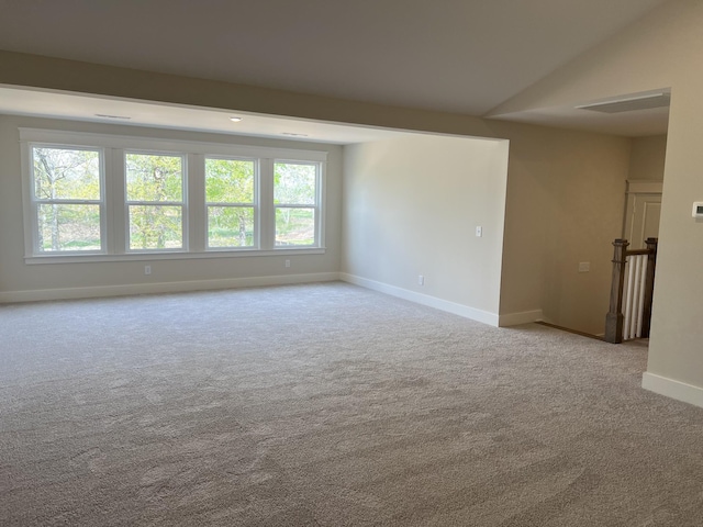 carpeted empty room featuring baseboards and a wealth of natural light