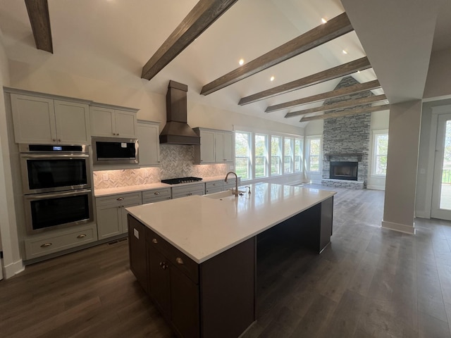 kitchen featuring stainless steel appliances, a sink, decorative backsplash, light countertops, and premium range hood