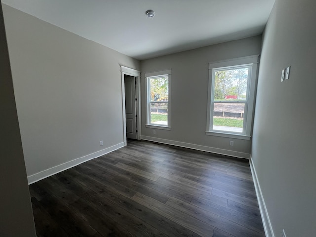 empty room with baseboards and dark wood-style floors