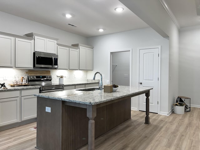 604 Rabbit Branch Rd, Shelbyville, TN 37160 - kitchen with appliances with stainless steel finishes, tasteful backsplash, a kitchen breakfast bar, light wood finished floors, and crown molding