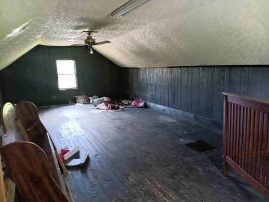 additional living space featuring wooden walls, vaulted ceiling, a ceiling fan, and hardwood / wood-style flooring