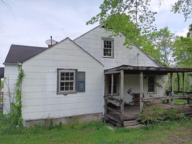 rear view of property with roof with shingles and a deck