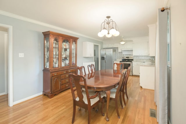 107 Hillis St, Mcminnville, TN 37110 - dining room featuring light wood-style flooring, visible vents, crown molding, and baseboards