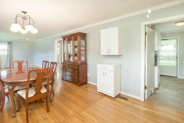 107 Hillis St, Mcminnville, TN 37110 - dining area with crown molding, light wood finished floors, baseboards, a notable chandelier, and visible vents
