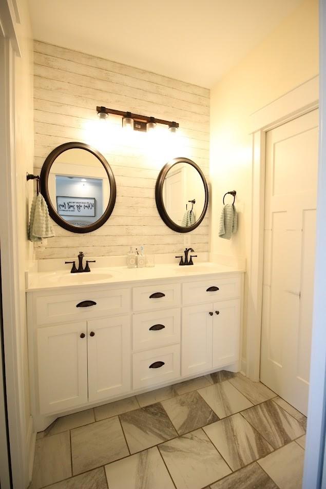 bathroom with wooden walls, double vanity, and a sink