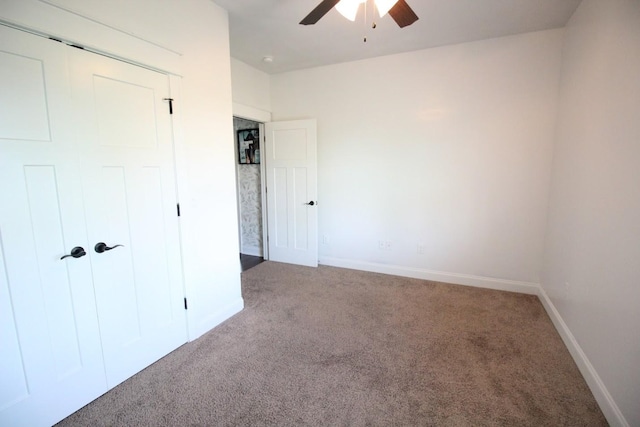 unfurnished bedroom featuring baseboards, carpet flooring, and a closet