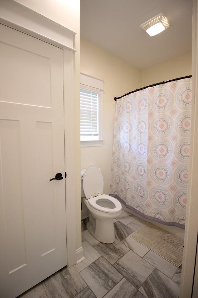 full bathroom featuring toilet and a shower with curtain