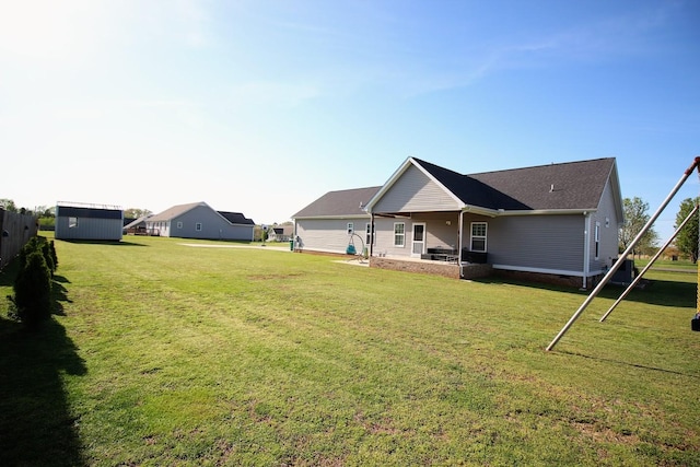 rear view of house with a lawn, crawl space, an outbuilding, and a storage unit