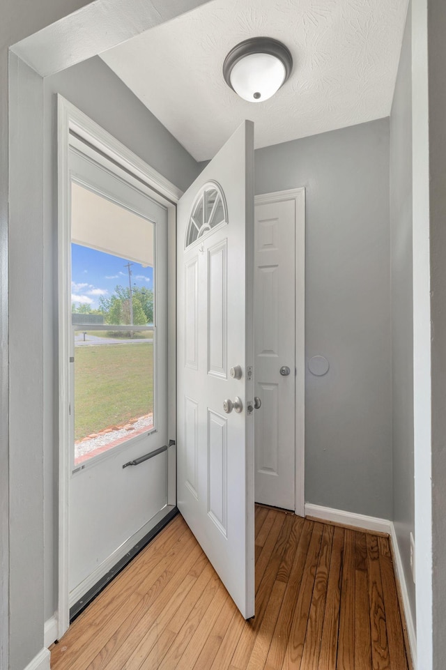 entryway featuring light wood-style flooring and baseboards