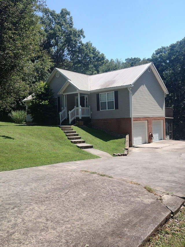 single story home with driveway, metal roof, an attached garage, a porch, and a front lawn