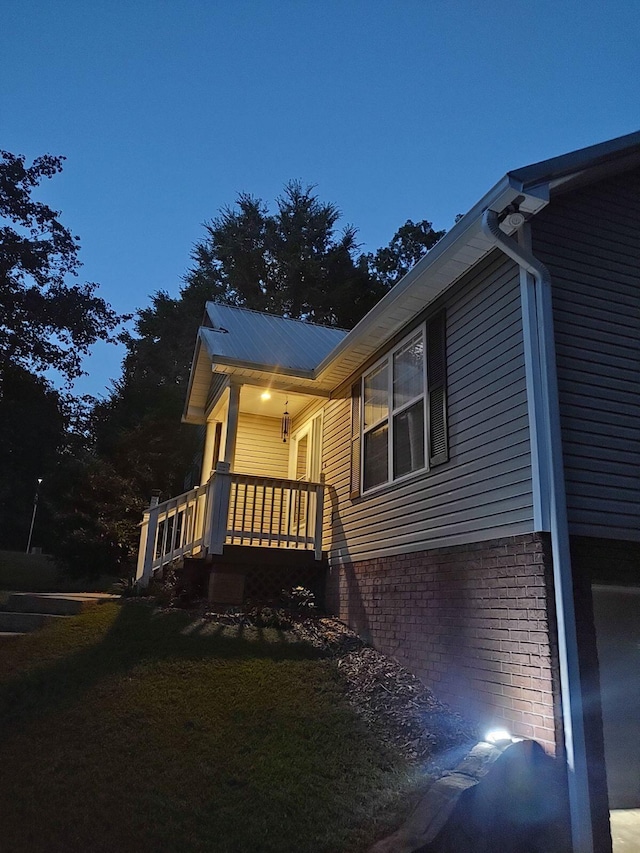 view of side of home with a porch and a yard