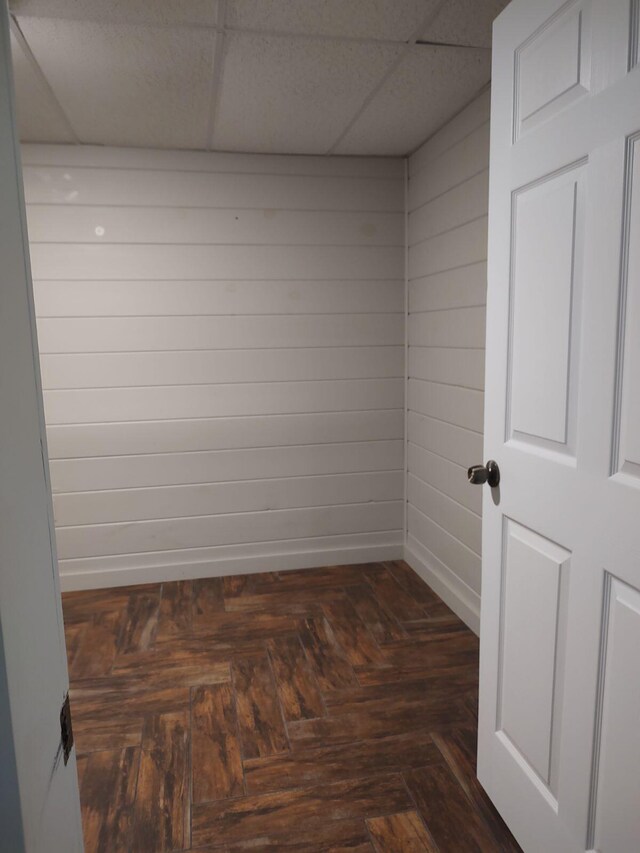 unfurnished room featuring baseboards and a drop ceiling
