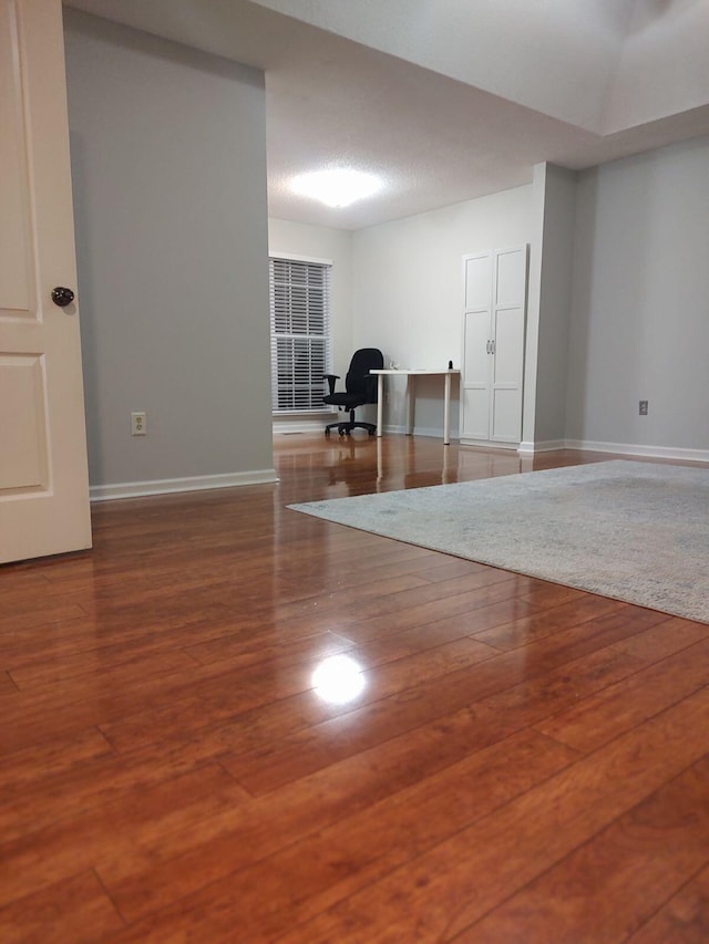 interior space with wood finished floors and baseboards