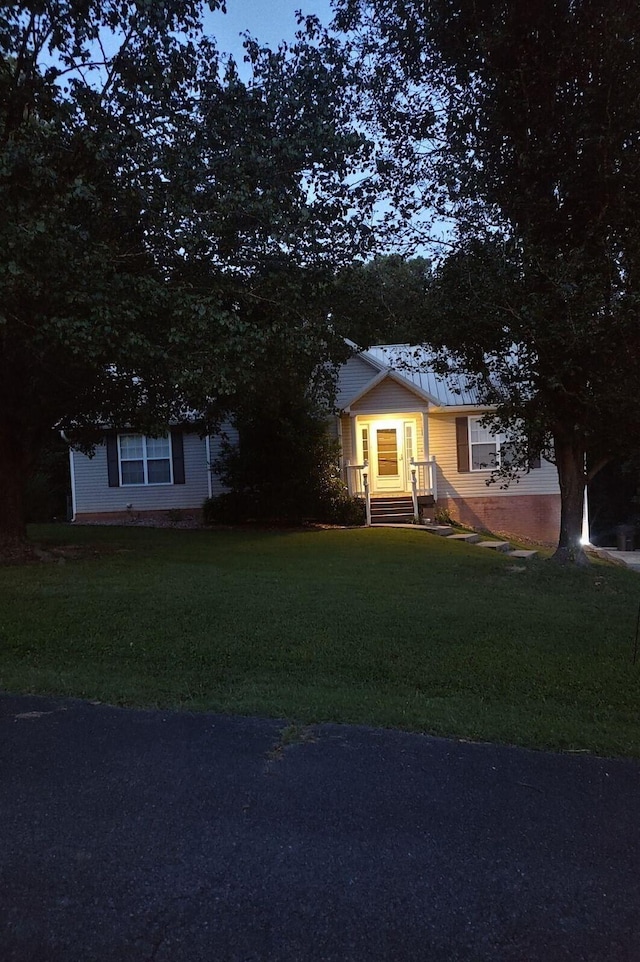 view of front of home featuring metal roof and a front yard