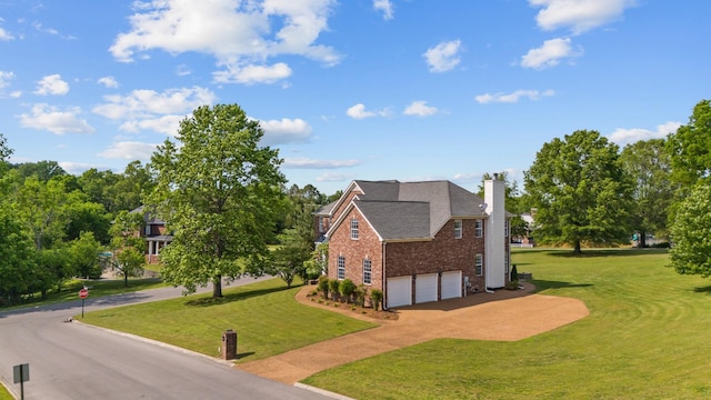 view of home's exterior featuring brick siding, a garage, a chimney, concrete driveway, and a yard