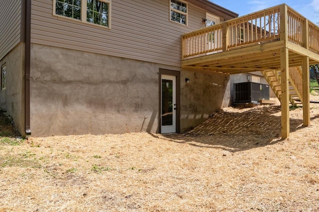 rear view of property featuring a wooden deck and stairs