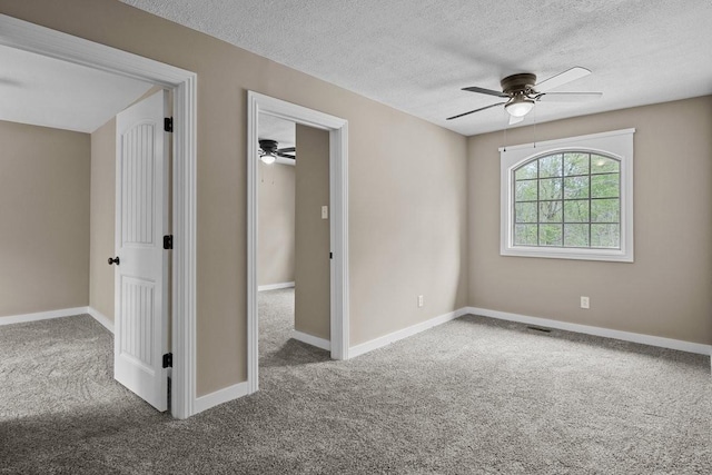 empty room with carpet floors, a textured ceiling, and ceiling fan