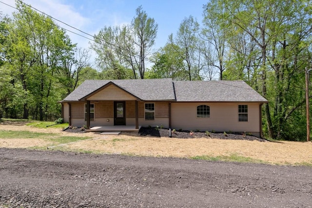 single story home featuring roof with shingles and covered porch