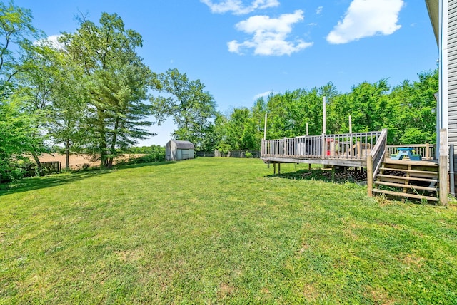 view of yard featuring an outbuilding, a storage shed, and a deck