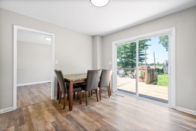 dining space featuring visible vents, baseboards, and wood finished floors