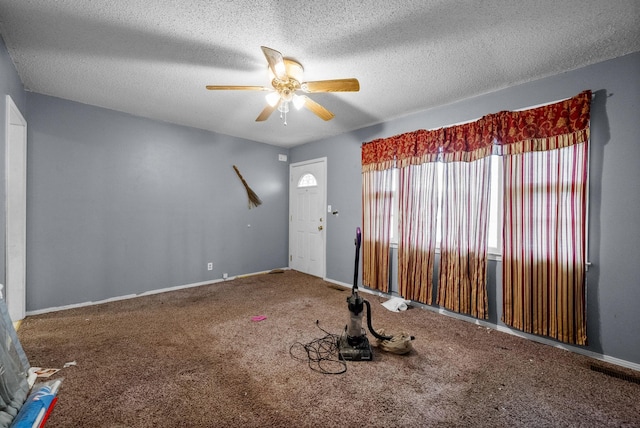 interior space featuring a textured ceiling, baseboards, and a ceiling fan