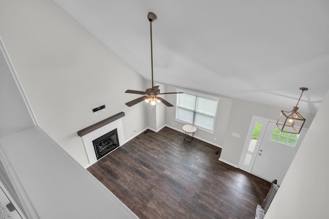 unfurnished living room with ceiling fan, baseboards, dark wood-style floors, and a fireplace