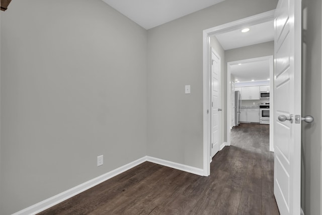 corridor with baseboards, recessed lighting, and dark wood-style flooring