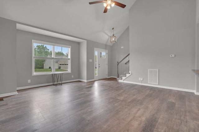 unfurnished living room featuring visible vents, stairs, ceiling fan, and dark wood-style flooring