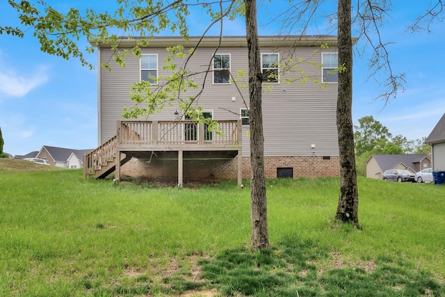 rear view of house with stairway, a wooden deck, a lawn, and crawl space