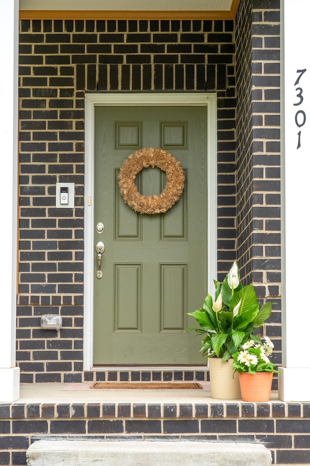 doorway to property featuring brick siding